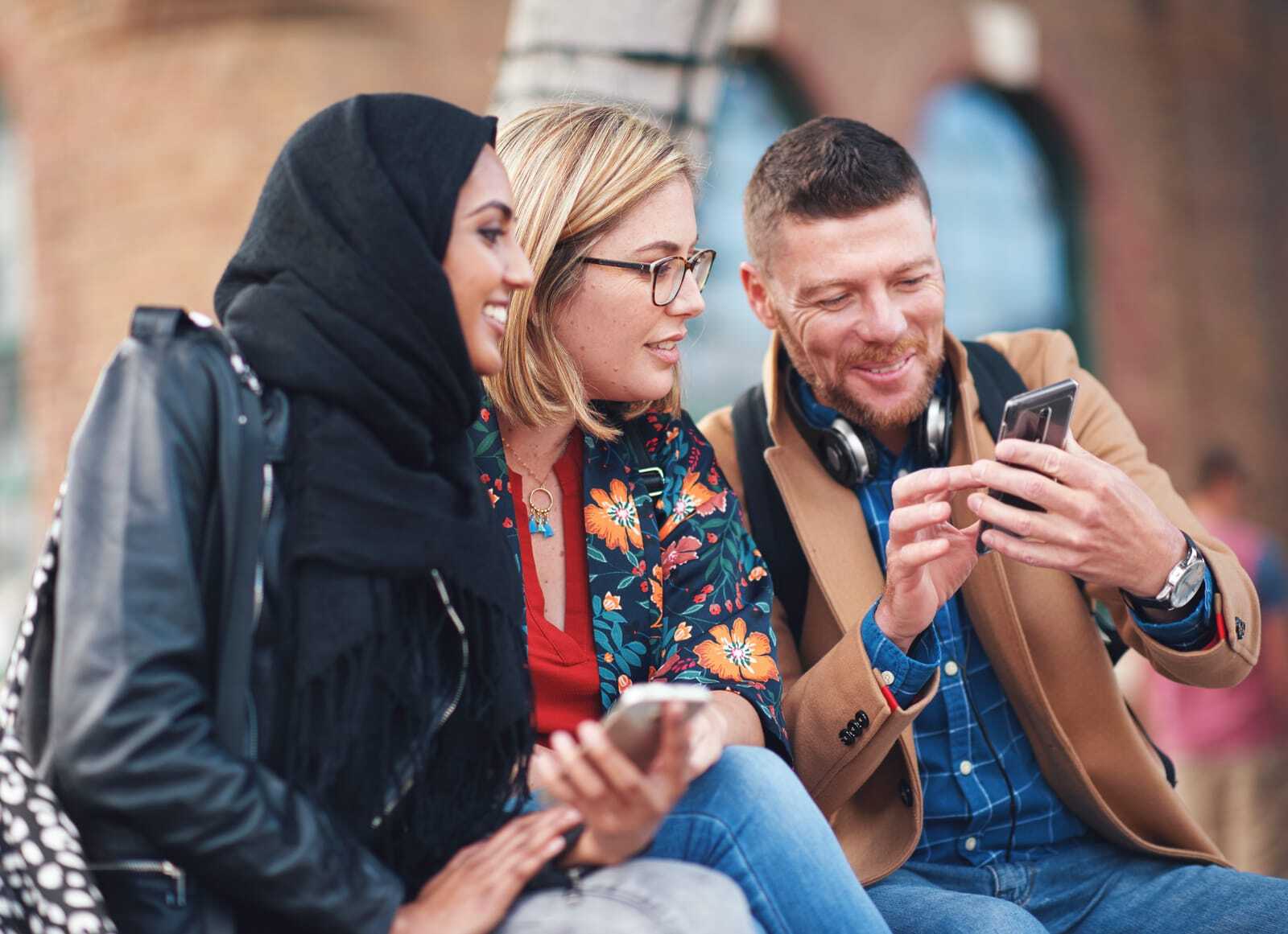 52347166_friends-diversity-and-happy-people-with-phone-communication-and-funny-meme-hijab-muslim-and-talking-women-and-adult-learning-group-and-international-student-community-on-college-steps